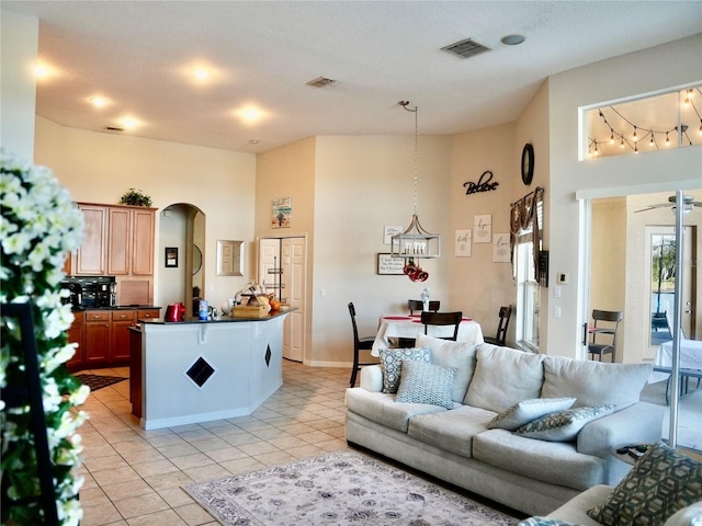 living room with a towering ceiling and light tile patterned flooring