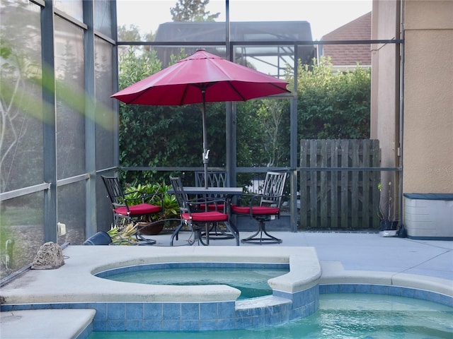 view of swimming pool featuring a patio, glass enclosure, and an in ground hot tub