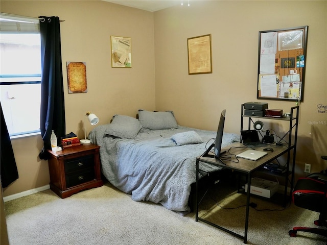 bedroom with light carpet and multiple windows