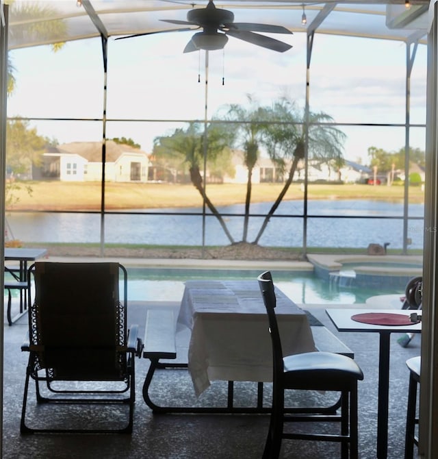 view of pool with ceiling fan and a water view