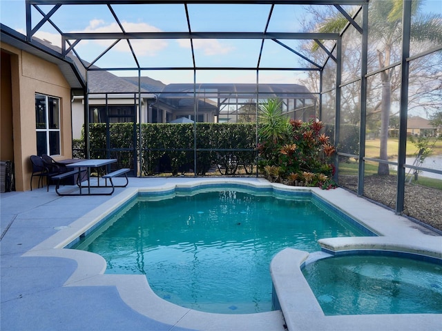 view of swimming pool featuring an in ground hot tub, a patio, and glass enclosure