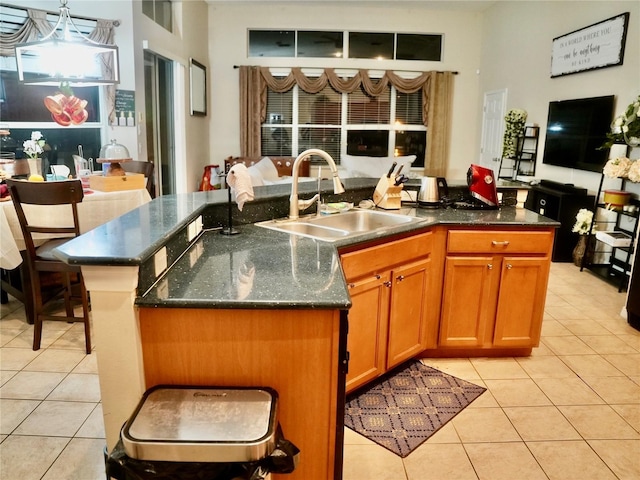 kitchen featuring light tile patterned flooring, sink, and a center island with sink