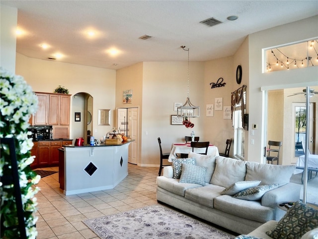 living room featuring light tile patterned floors and a towering ceiling