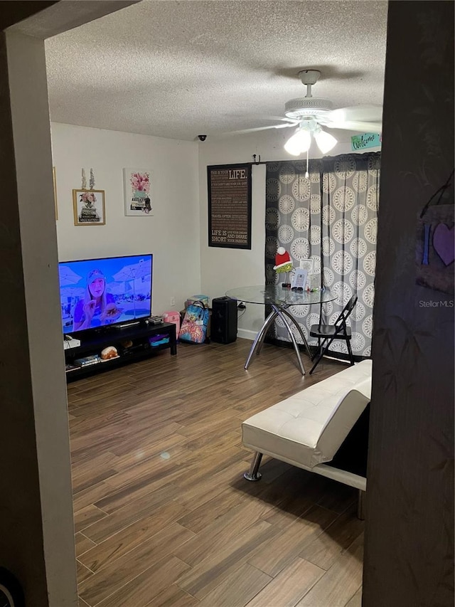 bedroom with a textured ceiling, ceiling fan, and hardwood / wood-style flooring