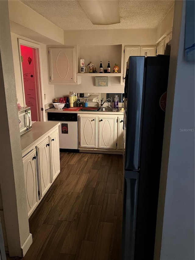 kitchen featuring dark hardwood / wood-style floors, sink, stainless steel appliances, a textured ceiling, and white cabinets