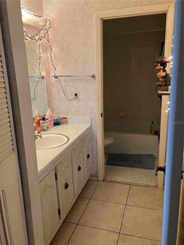 bathroom with toilet, vanity, and tile patterned flooring