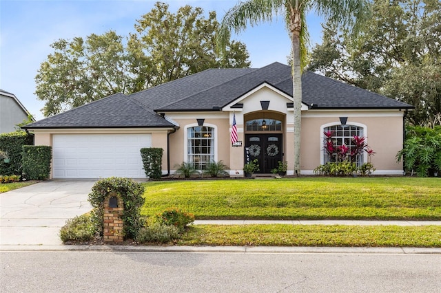 view of front of home featuring a front lawn, french doors, and a garage