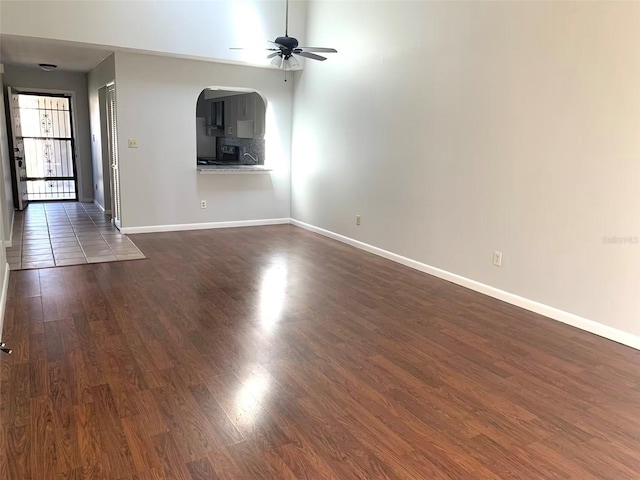 unfurnished living room with ceiling fan and dark hardwood / wood-style flooring