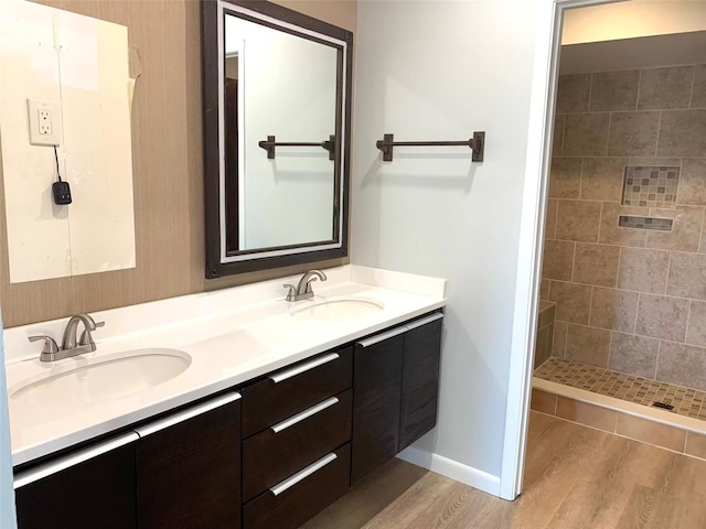 bathroom featuring vanity, tiled shower, and hardwood / wood-style floors