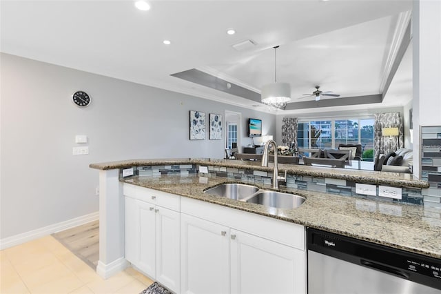 kitchen featuring sink, stainless steel dishwasher, a tray ceiling, light stone countertops, and white cabinets