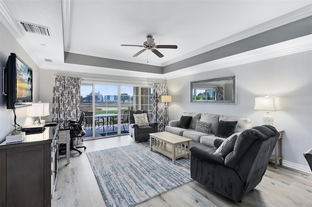 living room with a raised ceiling, crown molding, ceiling fan, and light hardwood / wood-style floors