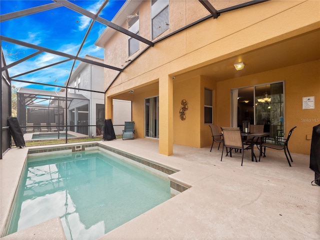 view of pool with a patio area, a lanai, and a hot tub