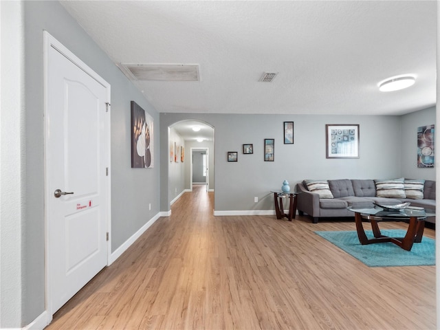 living room with light wood-type flooring and a textured ceiling