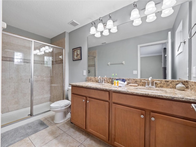 bathroom featuring a textured ceiling, tile patterned floors, a shower with door, vanity, and toilet