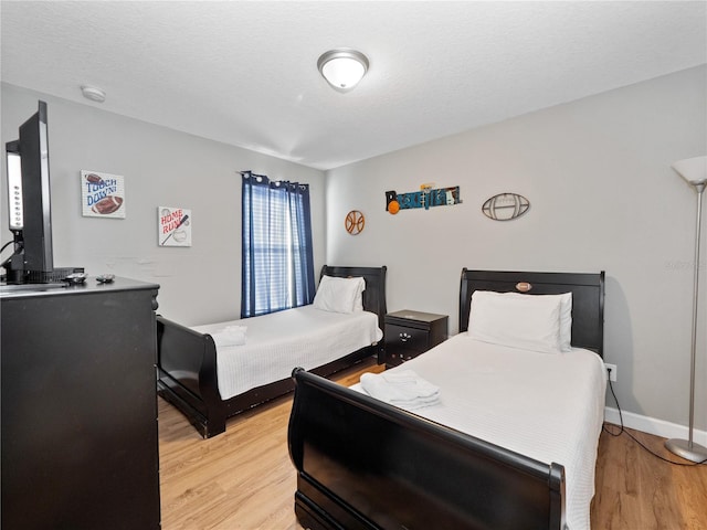 bedroom featuring light wood-type flooring and a textured ceiling