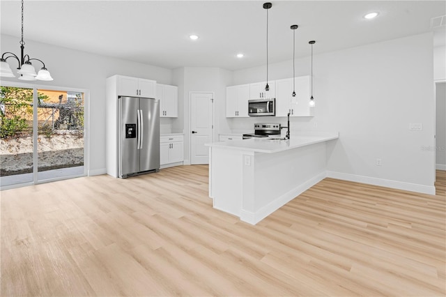 kitchen with white cabinetry, decorative light fixtures, light hardwood / wood-style flooring, kitchen peninsula, and stainless steel appliances