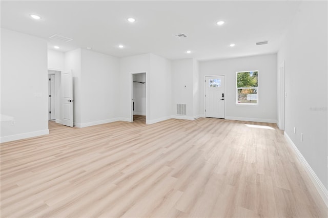 unfurnished living room featuring light wood-type flooring, visible vents, baseboards, and recessed lighting