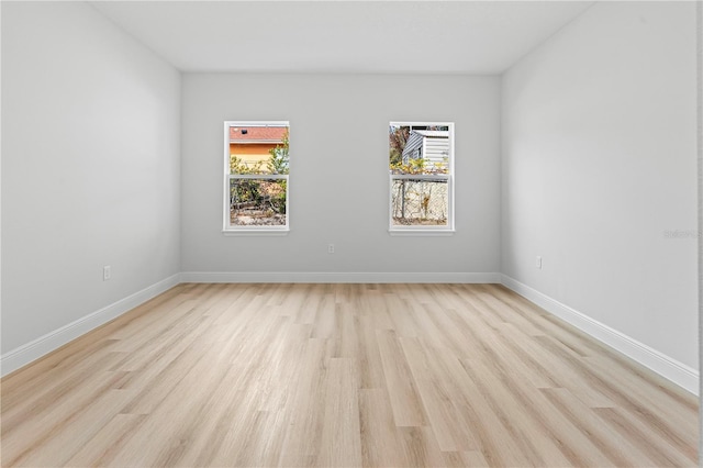 empty room with light wood-style flooring and baseboards