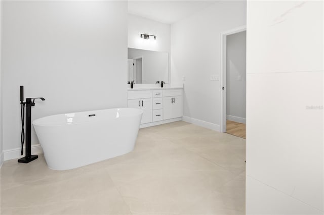 full bathroom with a soaking tub, baseboards, and vanity