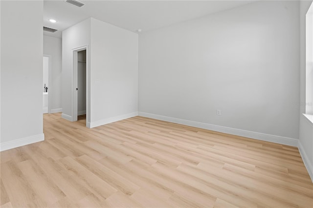 spare room featuring light wood finished floors, recessed lighting, visible vents, and baseboards