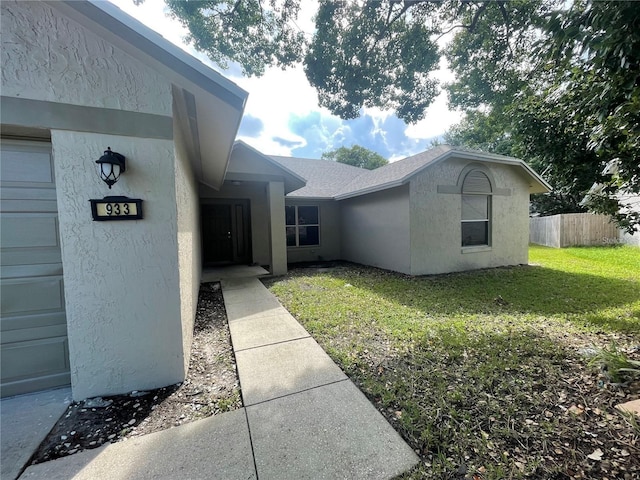 view of exterior entry with a lawn