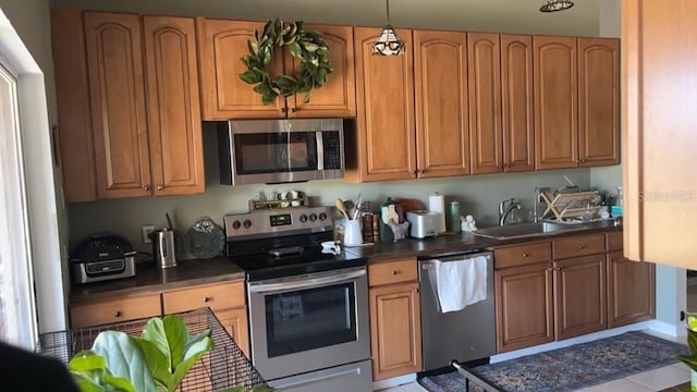 kitchen with pendant lighting, appliances with stainless steel finishes, and sink