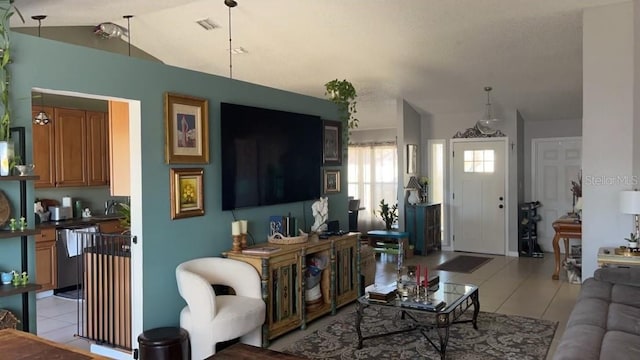 living room with vaulted ceiling, sink, and light tile patterned floors