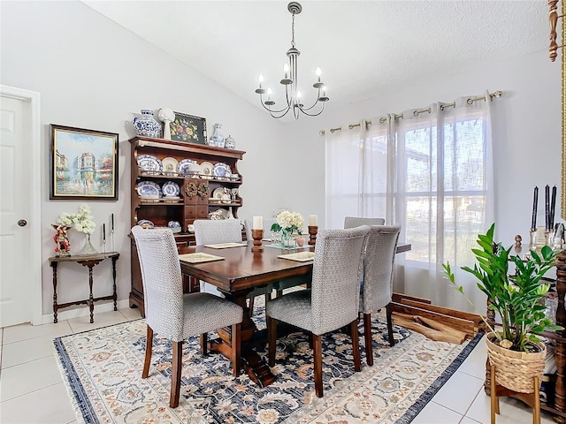 tiled dining space featuring vaulted ceiling, a textured ceiling, and a chandelier