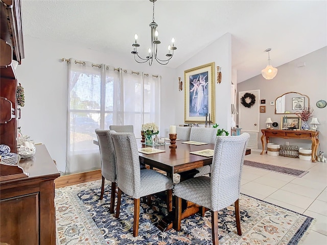 tiled dining area with lofted ceiling and a chandelier