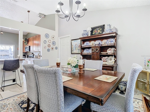 dining room with a chandelier, high vaulted ceiling, and light tile patterned floors