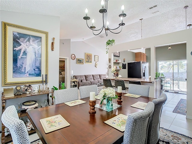 tiled dining room featuring vaulted ceiling, a textured ceiling, and a notable chandelier