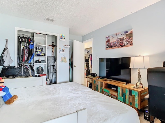 bedroom featuring a textured ceiling and a closet