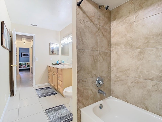 full bathroom featuring tiled shower / bath, vanity, toilet, and tile patterned flooring