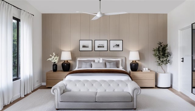 bedroom with ceiling fan, wood finished floors, and baseboards