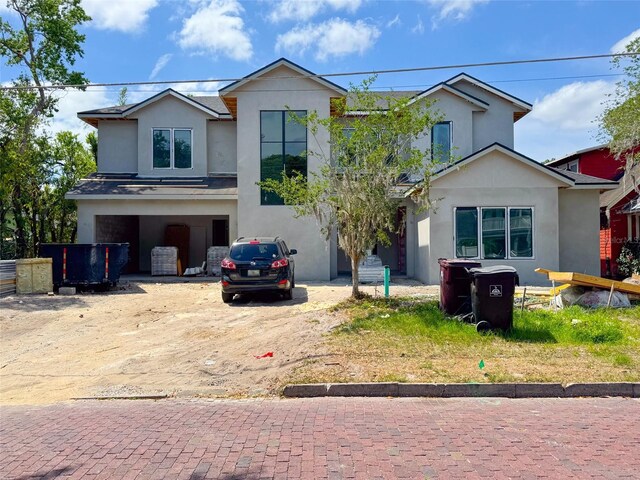 view of front of home with a garage, driveway, and stucco siding