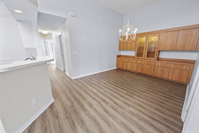 unfurnished dining area featuring a chandelier, sink, and hardwood / wood-style floors