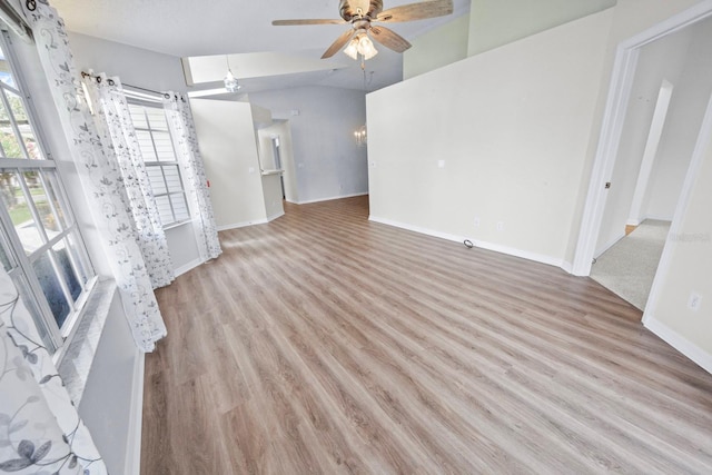 unfurnished living room with light hardwood / wood-style flooring, vaulted ceiling, and ceiling fan