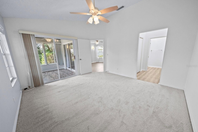 carpeted empty room featuring lofted ceiling