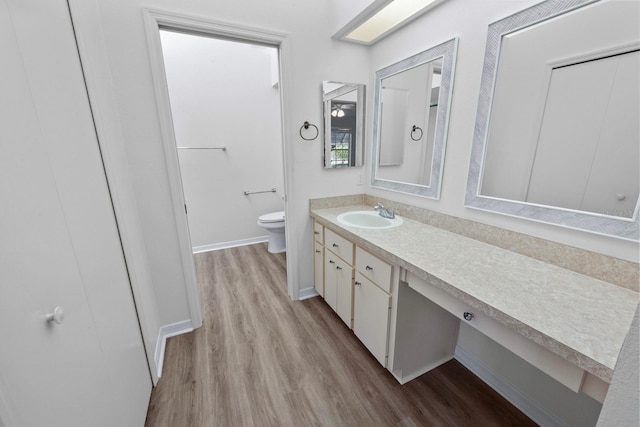 bathroom with vanity, toilet, and hardwood / wood-style floors