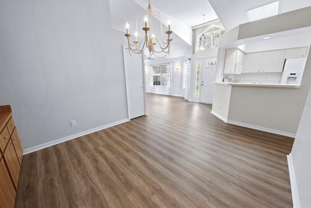 interior space with an inviting chandelier, hardwood / wood-style flooring, high vaulted ceiling, and a textured ceiling