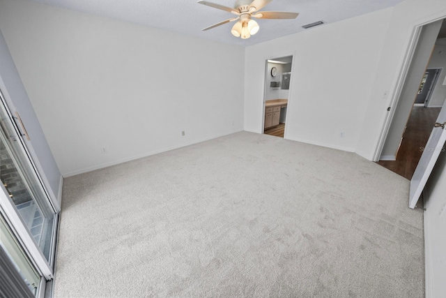 unfurnished bedroom featuring ensuite bathroom, ceiling fan, and carpet flooring