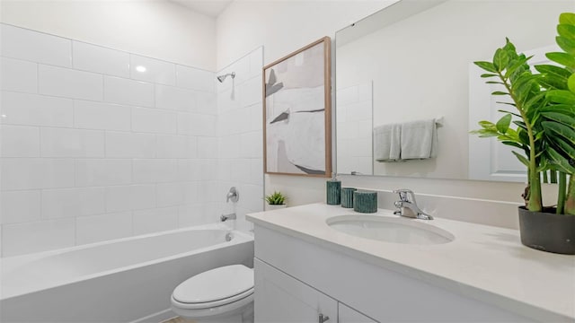 full bathroom featuring toilet, tiled shower / bath, and vanity