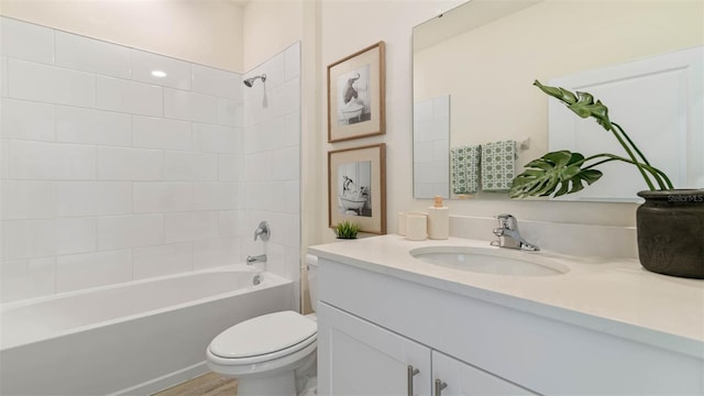 full bathroom with toilet, tiled shower / bath, and vanity