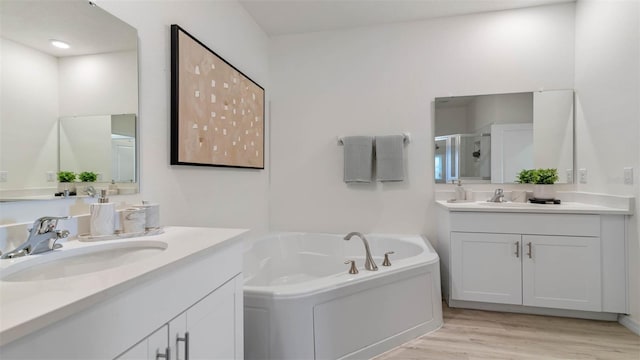 bathroom with wood-type flooring, vanity, and plus walk in shower