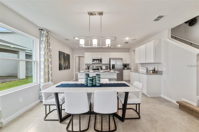 tiled dining space with an inviting chandelier