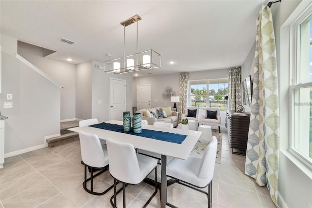 dining space featuring light tile patterned floors and a chandelier