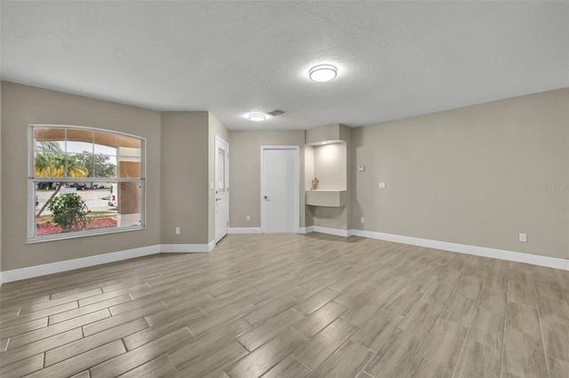 unfurnished room with a textured ceiling