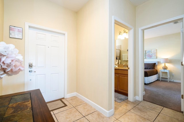 entryway with light tile patterned flooring and sink