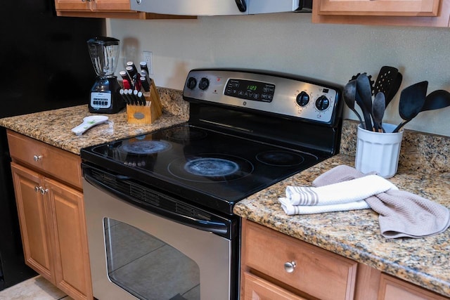 kitchen with light stone counters and stainless steel electric range