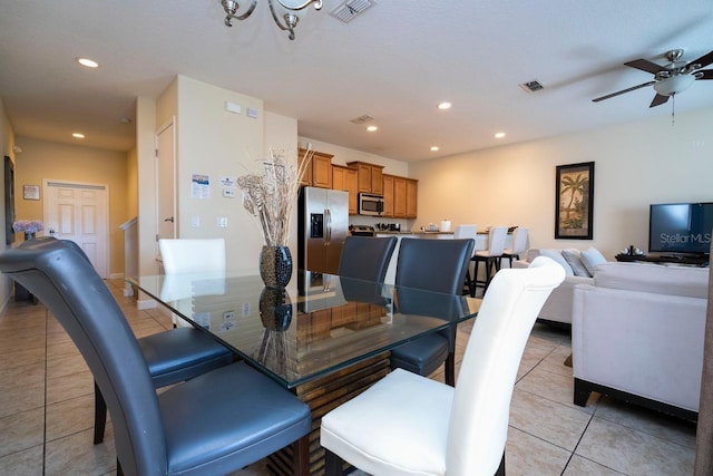 dining area featuring light tile patterned floors and ceiling fan with notable chandelier